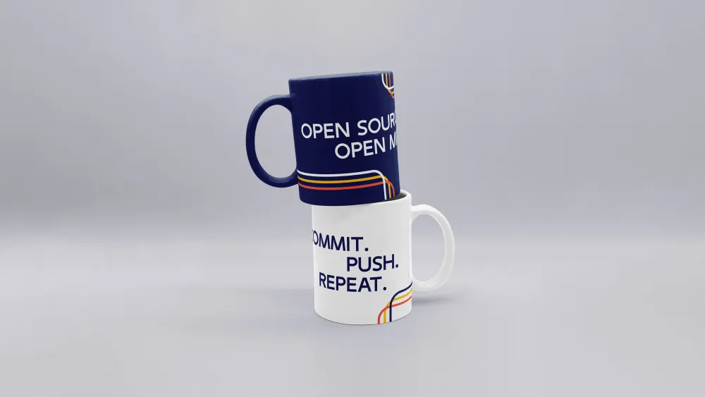 Zwei Kaffeetassen mit humorvollen Aufschriften, dunkelblaue und weiße Tasse
